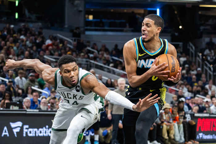 Indiana Pacers guard Tyrese Haliburton (0) dribbles the ball while Milwaukee Bucks forward Giannis Antetokounmpo (34)